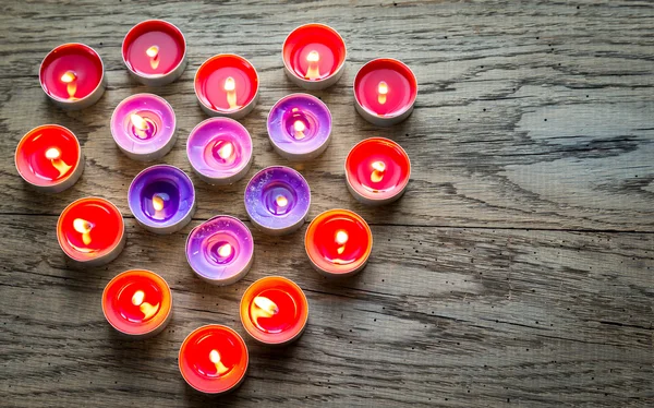 Brandende kaarsen, gerangschikt in de vorm van hart — Stockfoto