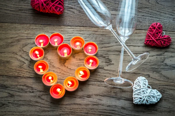 Velas encendidas en forma de corazón con dos flautas —  Fotos de Stock