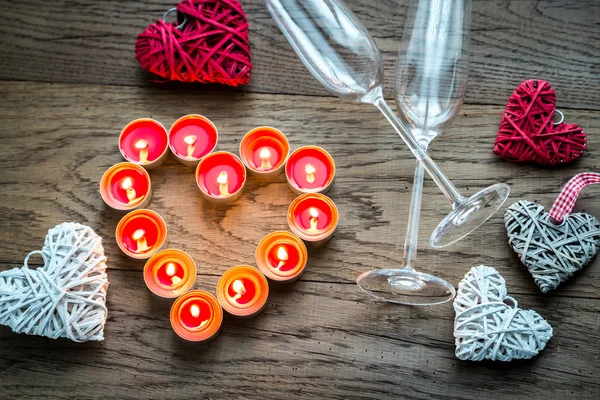 Queimando velas em forma de coração com duas flautas — Fotografia de Stock