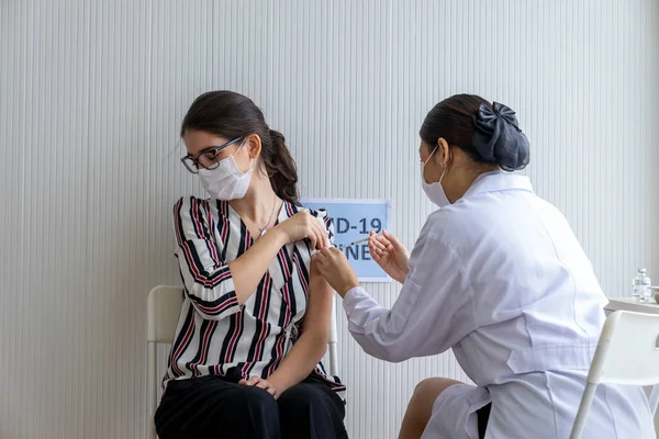 Coronavirüs salgınını önlemek için aşı istasyonunda ilk doz COVID-19 antiviral aşıyı alan beyaz bir kadın. Bağışıklık sistemi, Covid-19, Coronavirus küresel salgını