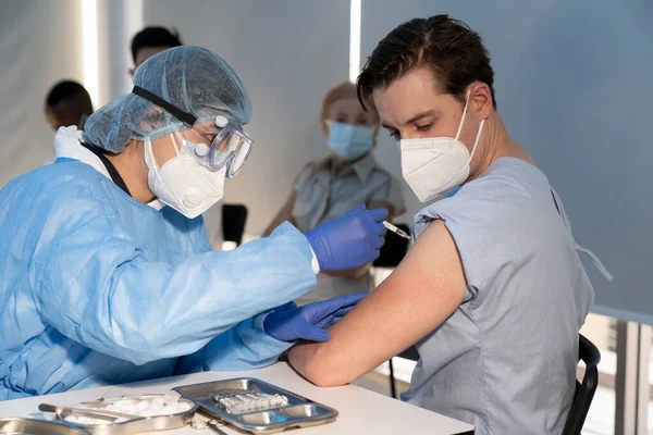 Bir doktor Coronavirus salgınını önlemek için hastanedeki beyaz insanlara kovid 19 aşısı enjekte ediyor. Bağışıklık sistemi, Covid-19 aşısı, Coronavirus küresel salgını.