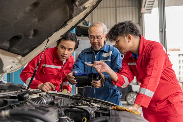Usta profesyonel tamirci otomotiv hatası kodlarını yorumlamak için obd2 araç tanılama cihazı tarayıcısı kullanıyor. Garaj atölyesindeki yaşlı araç tamircisi. Servisi otomatik onar