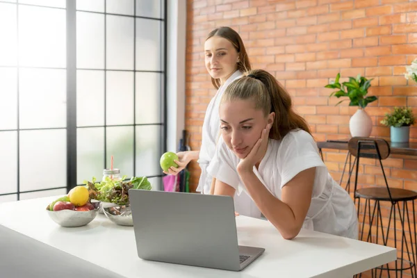 Beyaz bornozlu sağlıklı kadınlara odaklanın vejetaryen diyet tarifi bulmak için laptop kullanın, marketten internetten yemek sipariş edin. Çevrimiçi alışveriş, yemek servisi konsepti.