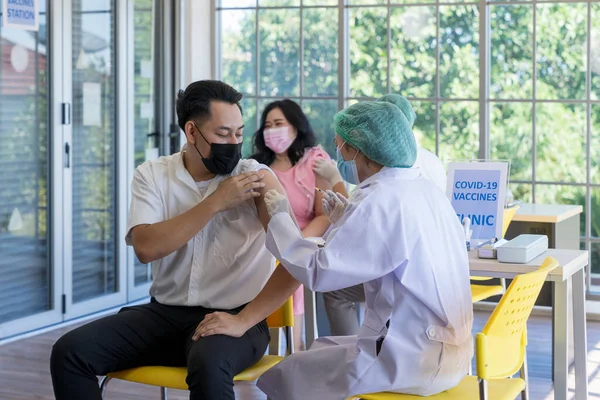 Bir doktor Coronavirüs salgınını önlemek için hastanedeki Asyalılara kovid 19 aşısı enjekte ediyor. Bağışıklık sistemi, Covid-19 aşı kliniği, Coronavirus küresel salgını.
