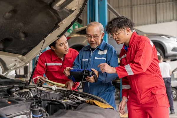 Usta profesyonel tamirci otomotiv hatası kodlarını yorumlamak için obd2 araç tanılama cihazı tarayıcısı kullanıyor. Garaj atölyesindeki yaşlı araç tamircisi. Servisi otomatik onar