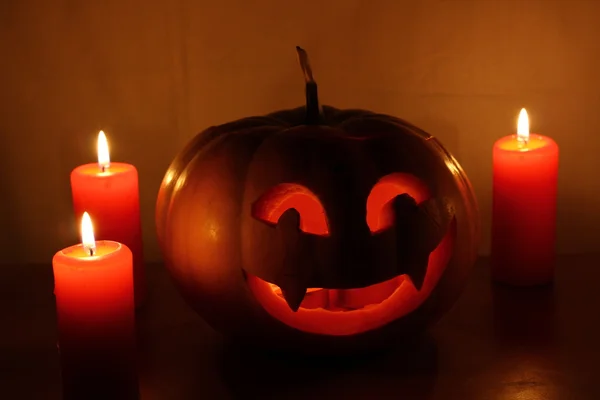 Calabaza de Halloween aterradora con velas sobre un fondo oscuro — Foto de Stock