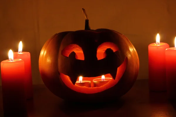 Calabaza de Halloween aterradora con velas sobre un fondo oscuro — Foto de Stock