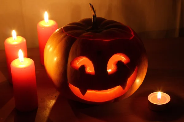 Calabaza de Halloween aterradora con velas sobre un fondo oscuro — Foto de Stock