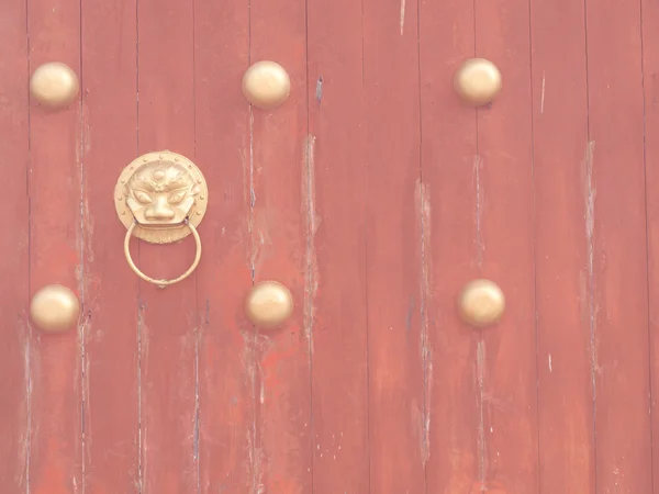 Portão de madeira vermelho antigo com batedor de porta de leão em estilo vintage — Fotografia de Stock