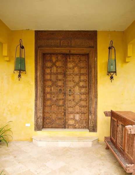 Antique Moroccan style wooden door  on yellow wall — Stock Photo, Image