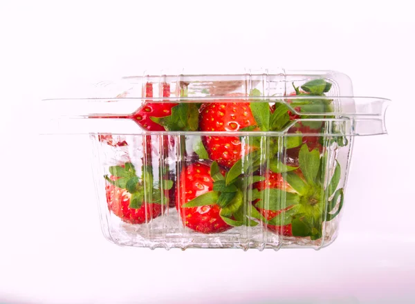 Taze çilek şeffaf plastik kutusunda Isolated beyaz ba kazıklı