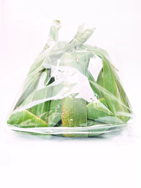 Paquets de desserts thaïlandais fabriqués à partir de feuilles de banane dans un sac en plastique transparent isolé sur fond blanc — Photo