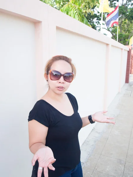 Young Asian lady wearing sunglasses expressing something in natu — Stock Photo, Image