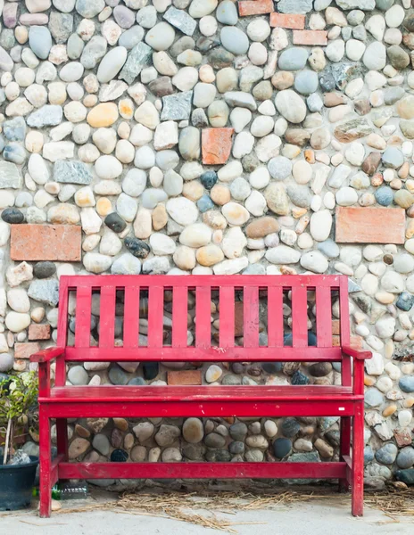 Red wooden bench and stone wallbackground — Stock Photo, Image