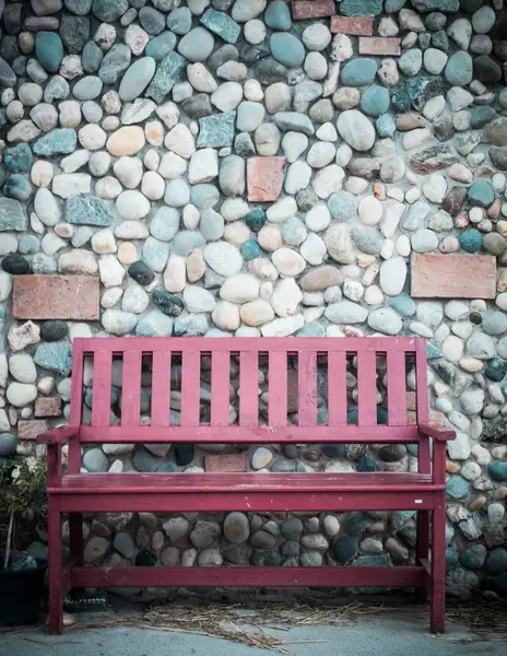 Red wooden bench and stone wall background in retro style — Stock Photo, Image