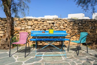 Folegandros adasındaki Chora kasabasında renkli sandalyeler ve banklar. Cyclades, Yunanistan