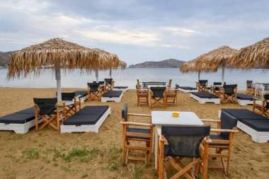 Ios, Yunanistan - 19 Eylül 2020: Ios Adası 'ndaki kumlu Chora plajında şemsiyeli plaj salonları. Cyclades, Yunanistan