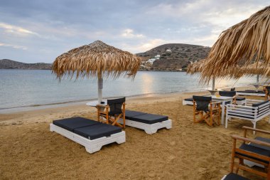 Ios, Yunanistan - 19 Eylül 2020: Ios Adası 'ndaki kumlu Chora plajında şemsiyeli plaj salonları. Cyclades, Yunanistan