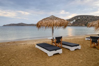 Ios, Yunanistan - 19 Eylül 2020: Ios Adası 'ndaki kumlu Chora plajında şemsiyeli güneş panzeleri. Cyclades, Yunanistan