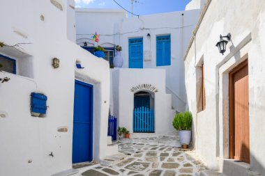 Paros Adası 'ndaki Lefkes köyünde beyazlatılmış caddede mavi pencereli ve kapısı olan tipik bir Yunan evi. Cyclades, Yunanistan