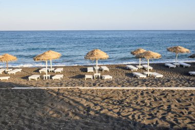 Perissa 'da volkanik kumu olan Black Beach, Santorini' de bir turizm merkezi. Cyclades, Yunanistan