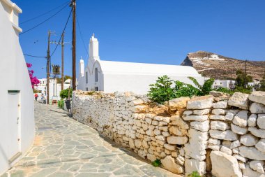 Folegandros, Yunanistan - 23 Eylül 2020: Folegandros 'ta Chora' da beyaz bir kilisesi olan Cobbled Caddesi. Cyclades Adaları, Yunanistan