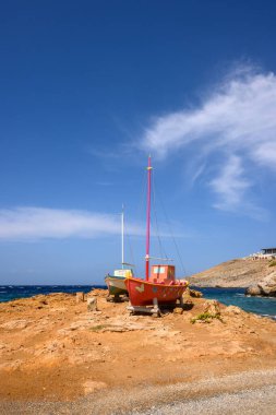 Ios, Yunanistan - 20 Eylül 2020: Ios Adası 'ndaki Koumbara sahilinin kayalık sahillerindeki renkli tekneler. Yunanistan