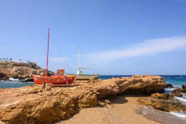 Ios, Yunanistan - 20 Eylül 2020: Ios Adası 'ndaki Koumbara sahilinin kayalık sahillerindeki renkli tekneler. Yunanistan