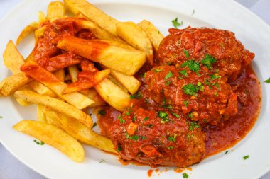 Domates soslu kıymalı pirzola ve patates kızartması. Geleneksel Yunan yemeği.