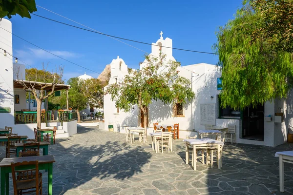 Folegandros, Yunanistan - 23 Eylül 2020: Folegandros Adası 'ndaki kilise ve restoranların bulunduğu küçük bir meydan. Cyclades, Yunanistan