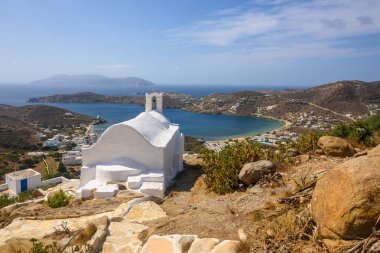 View of Ios Island with a small white chapel on top of a mountain in the city center of Chora. Ios Island. View of the bay and the Aegean Sea. Cyclades, Greece