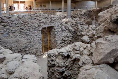 Santorini, Yunanistan - 18 Eylül 2020: Ege 'nin en önemli tarih öncesi yerleşimlerinden biri olan tarih öncesi Akrotiri kasabasında bulunan antik binalar. Yunanistan 'ın Santorini kentindeki Akrotiri arkeolojik sahası