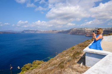 Santorini, Yunanistan - 18 Eylül 2020: Bir turist Santorini Körfezi 'nin fotoğrafını çekiyor. Yunanistan