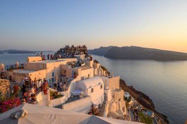Santorini, Yunanistan - 17 Eylül 2020: Santorini 'nin ünlü turistik merkezi, gün batımında Oia köyü.