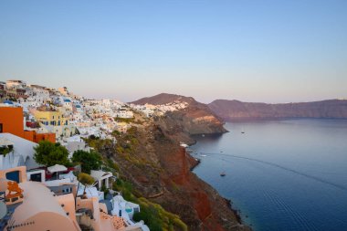 Santorini, Yunanistan - 17 Eylül 2020: Oia köyündeki Santorini adasının kıyıları gün batımında, Kiklad, Yunanistan