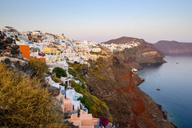 Santorini, Yunanistan - 17 Eylül 2020: Oia köyündeki Santorini adasının kıyıları gün batımında, Kiklad, Yunanistan