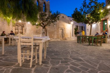 Folegandros, Yunanistan - 23 Eylül 2020: Folegandros Adası 'ndaki eski kilise ve restoranların bulunduğu küçük bir meydan. Cyclades, Yunanistan