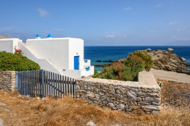 Folegandros, Yunanistan - 24 Eylül 2020: Denize bakan mavi pencereli Whitewashed yazlık villa. Folegandros Adası, Yunanistan