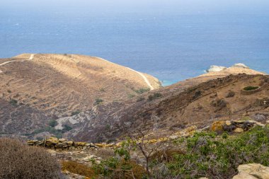 Folegandros adasının vahşi kıyıları. Tepelerin yamaçlarında taş teraslar. Cyclades, Yunanistan