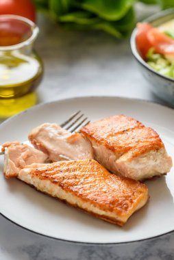 Somon parçaları kızarmış ve bir tabakta servis ediliyor..