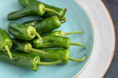 Bir tabakta yeşil kırmızı biberli Padron grubu.