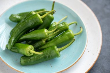 Bir tabakta yeşil kırmızı biberli Padron grubu.