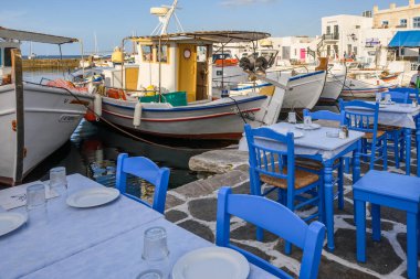 Paros, Yunanistan - 27 Eylül 2020: Balık lokantasında masa ve sandalyeler. Paros Adası 'ndaki Naoussa limanı. Cyclades, Yunanistan