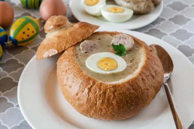 Ekmek kabında servis edilen sosis ve yumurtalı çavdar unundan yapılan ekşi çorba (zurek). Popüler Paskalya yemeği.