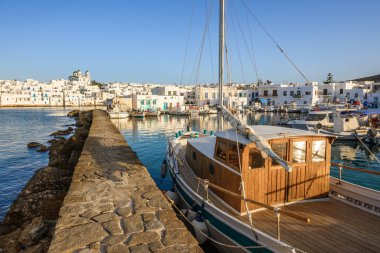 Yunanistan 'ın Paros adasında, arkasında geleneksel Yunan evleri bulunan Naoussa limanında bir tekne. Kiklad.