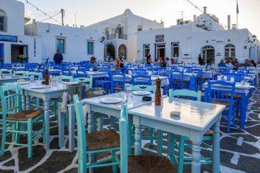 Paros, Yunanistan - 27 Eylül 2020: Paros Adası 'ndaki güzel Naoussa limanındaki deniz kenarı balık restoranında masa ve sandalyeler. Cyclades, Yunanistan