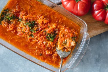 Maydanozla süslenmiş sebzeli domates soslu alabalık.