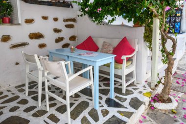 Antiparos, Yunanistan - 28 Eylül 2020: Antiparos adasındaki Yunan kafesinde masa ve sandalyeler. Cyclades, Yunanistan
