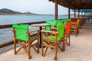 Antiparos, Yunanistan - 28 Eylül 2021: Antiparos adasındaki Yunan sahil restoranında masa ve sandalyeler. Cyclades, Yunanistan
