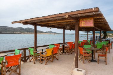 Antiparos, Yunanistan - 28 Eylül 2021: Antiparos adasındaki Yunan sahil restoranında masa ve sandalyeler. Cyclades, Yunanistan